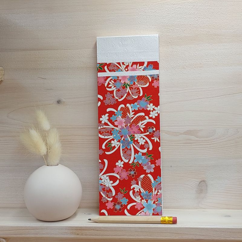 Bloc à listes aux feuillets détachables recouverts de papier japonais rouge décoré de rubans blancs avec un motif de fleurs roses, bleues et mauves