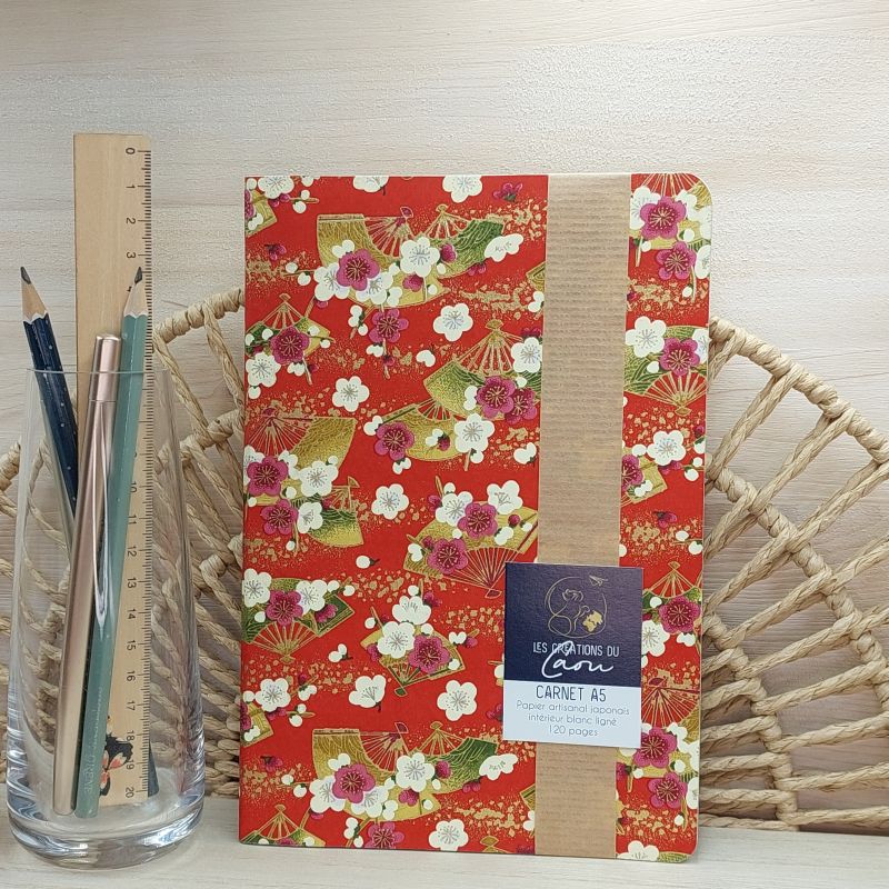 La couverture souple de ce carnet A5 (papier ligné-120 pages) est recouverte à la main d’un délicat papier artisanal japonais au motif d'éventails, dans les tons bordeaux rouge, beige et doré.